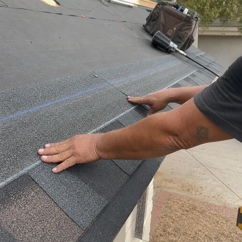 Professional roofing crew performing a residential roof replacement and shingle installation.